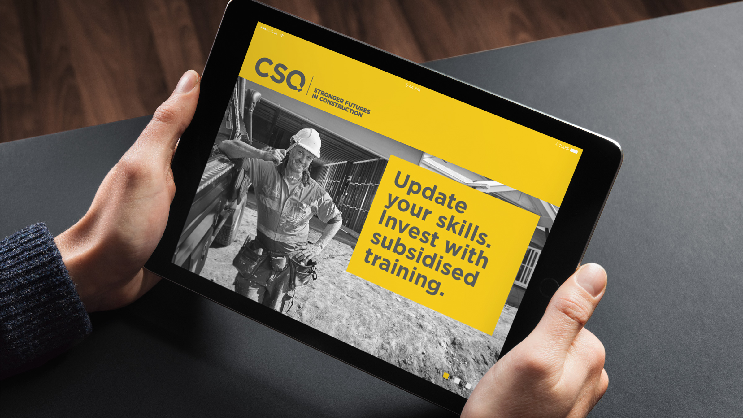A landing page on a tablet part of the CSQ advertising campaign. It features a tradie tapping his hard hat with a pencil. The copy reads "update your skills. Invest with subsidised training."