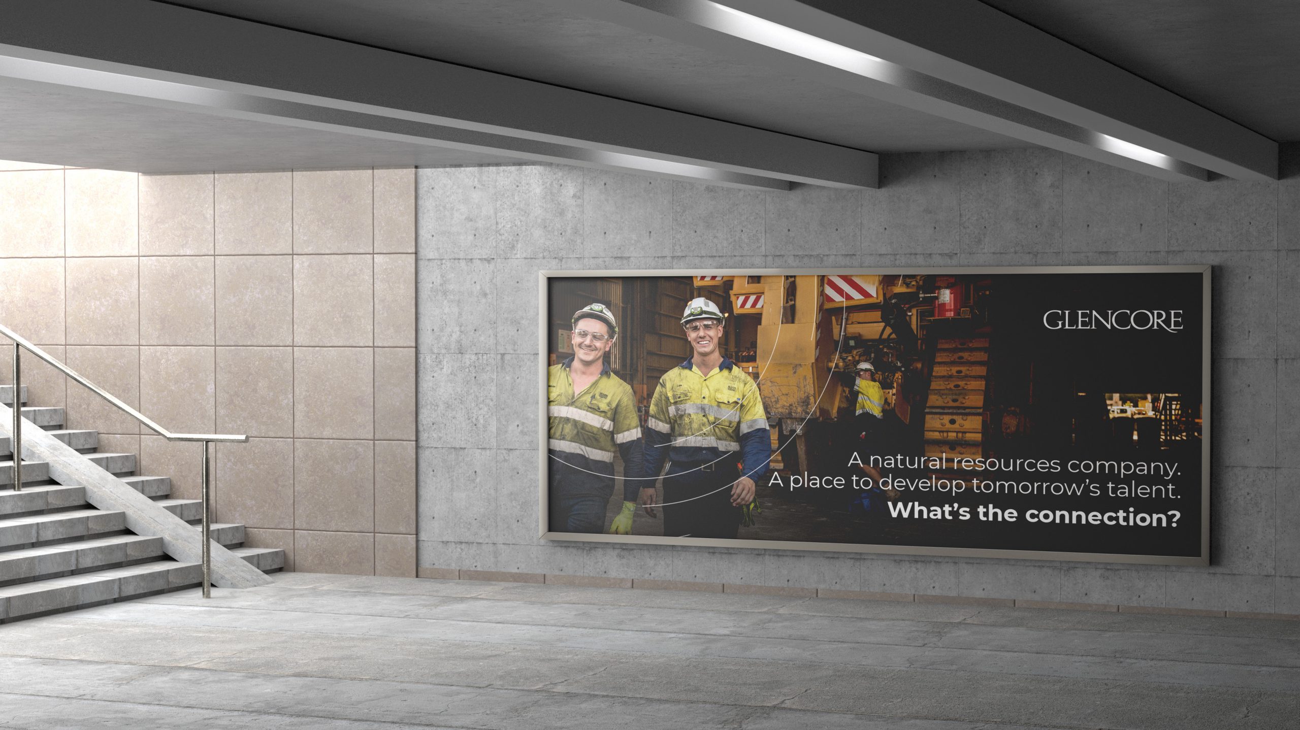 An out of home billboard part of the Glencore advertising campaign. Two mine workers, both men stand in front of a large mining truck with smiles on their faces. The headline reads "A natural resources company. A place to develop tomorrow's talent."